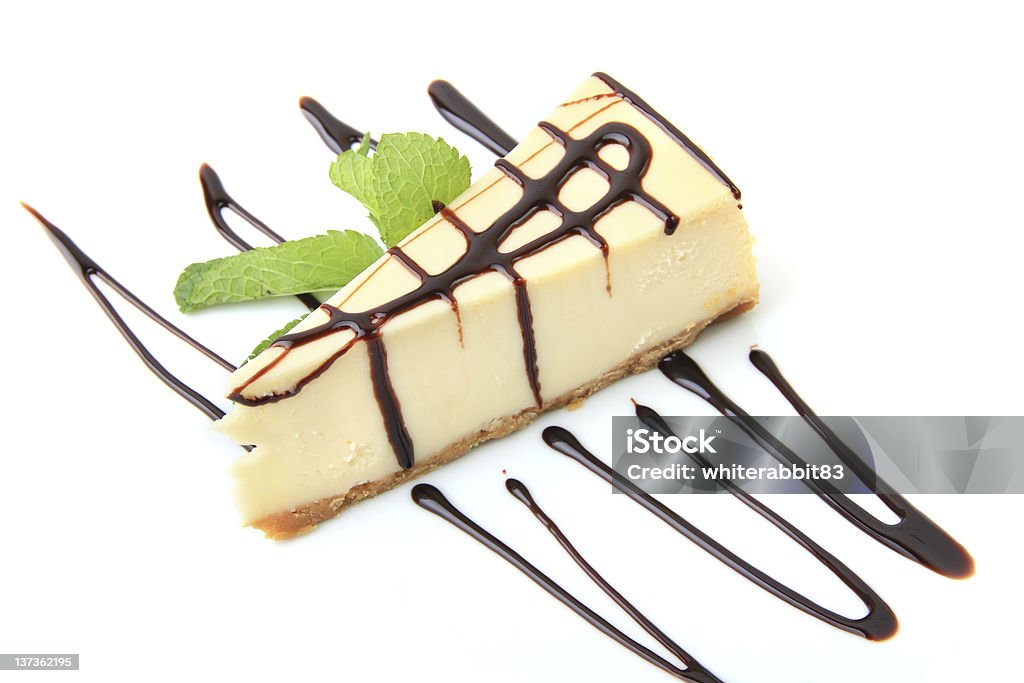 vanilla cheesecake with mint Piece of vanilla cheesecake with mint twig over white background Baked Stock Photo