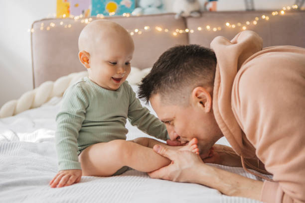 istock Father and baby playing on bed 1373625457