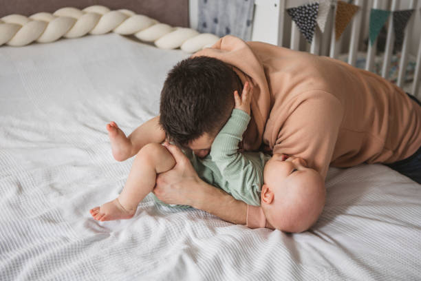 istock Father and baby playing on bed 1373625461