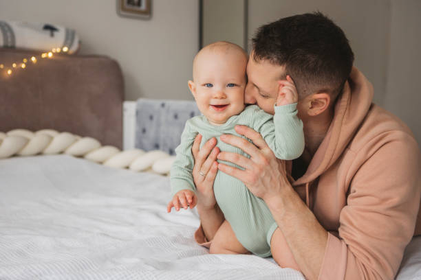 istock Father and baby playing on bed 1373625462