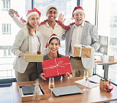 Shot of a group pf businesspeople exchanging Christmas gifts in an office