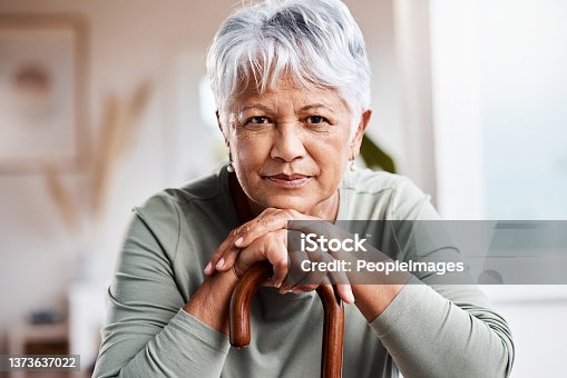 istock Shot of a senior woman leaning in her walking stick at home 1373637022