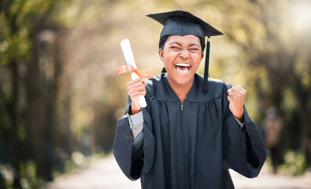 졸업일에 응원하는 젊은 여성의 초상화 - graduation women fist celebration 뉴스 사진 이미지