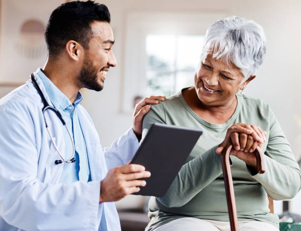 shot of a young doctor sharing information from his digital tablet with an older patient - healthcare stockfoto's en -beelden
