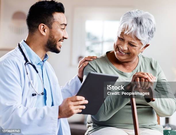 Shot Of A Young Doctor Sharing Information From His Digital Tablet With An Older Patient Stock Photo - Download Image Now