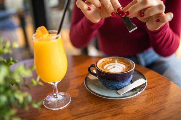 istock Woman adding sugar to her coffee in coffee shop 1373665454
