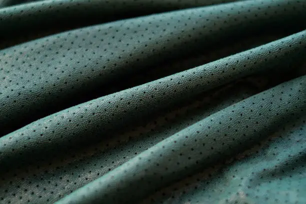 Photo of Green genuine leather background, perforated fabric, close-up