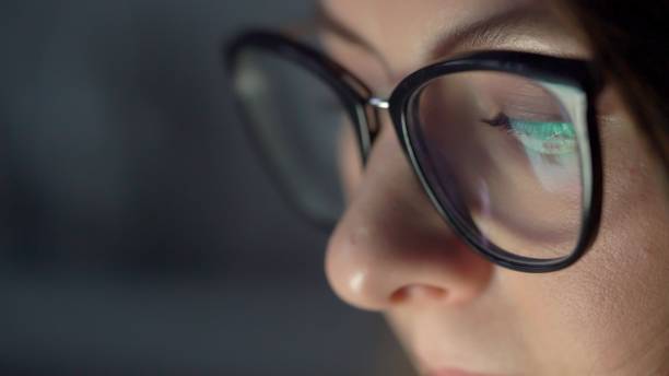 istock Young woman in glasses uses computer, tablet, smartphone. Reflection of display 1373689034