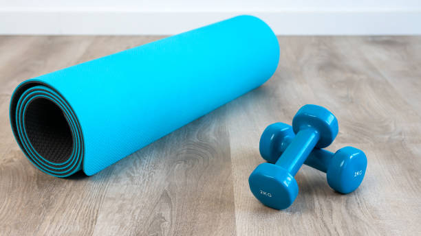 istock Exercise with two blue dumbbells and mat preparing for yoga sports training 1373689160