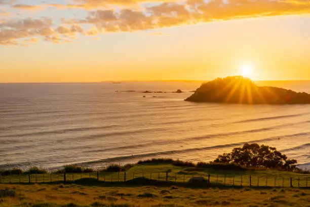 Sun rises over ocean and coastal beaches of Bay of Plenty viewed from Mount Maunganui.