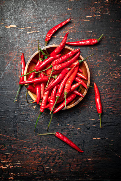 istock Wooden plate with hot chili peppers. 1373703182