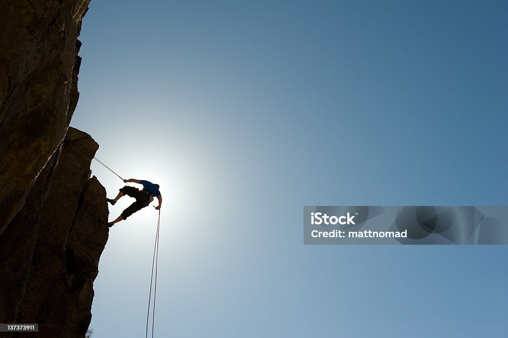 Rápel escalador mirando hacia abajo - Foto de stock de Acantilado libre de derechos