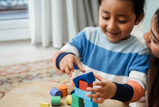 mãe asiática e filho criança se divertindo jogando jogos com blocos de brinquedos de madeira em casa - tempo em família juntos - native american baby love mother - fotografias e filmes do acervo