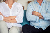 Mature couple fighting at home sitting on the sofa.