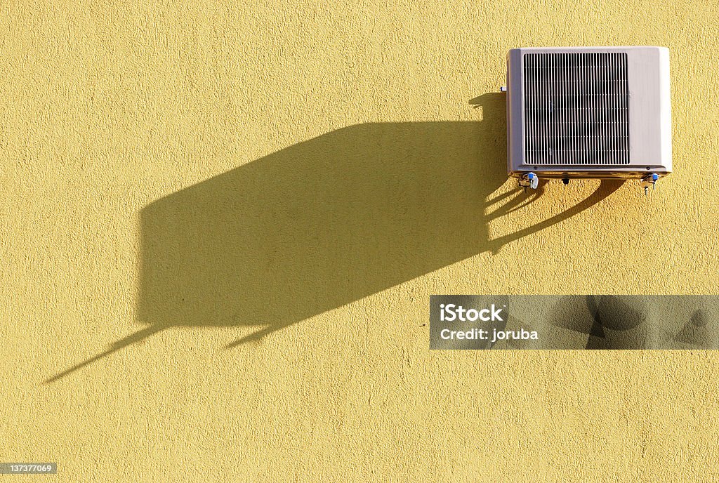 Air conditioner Air conditioner on yellow wall with shadow Abstract Stock Photo