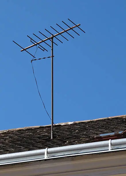 Television antenna on the roof over blue sky