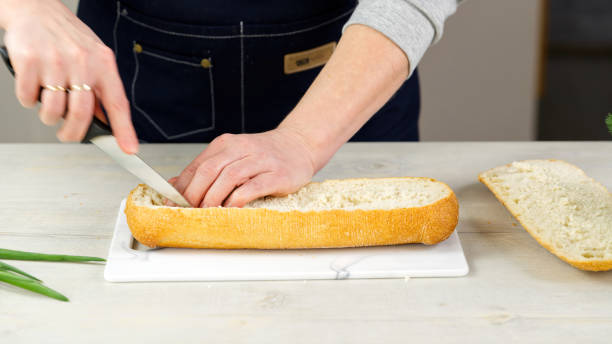 istock the cook cuts fresh ciabatta bread. Pulls out the pulp from the inside. Makes a base for stuffing bread. huge sandwich making process 1373795559