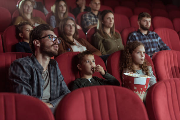 Single father with kids in cinema stock photo