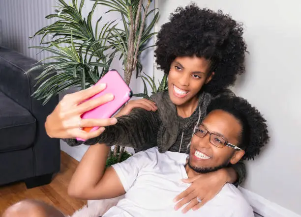 Husband and wife with Afro hair style  making selfie photo with smartphone. copy space for text message or design