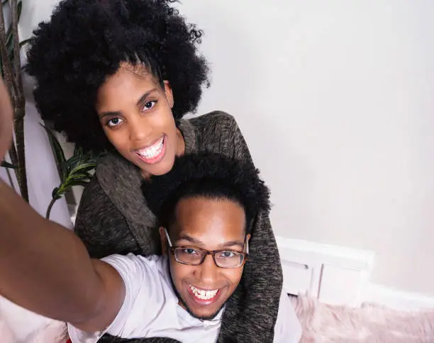 Closeup portrait of Latin young couple of lovers taking a selfie portrait, Afro hair style. copy space for text message or design.