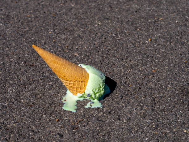 istock Dropped Mint Chocolate Chip ice cream cone melting on pavement. 1373841912
