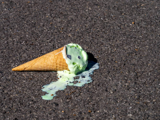 istock Dropped Mint Chocolate Chip ice cream cone melting on pavement. 1373841915