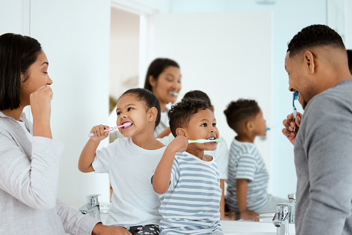 Shot of a beautiful family brushing their teeth together at home