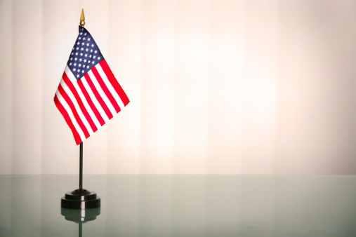 American flag on a glass table, office like setting; copyspace