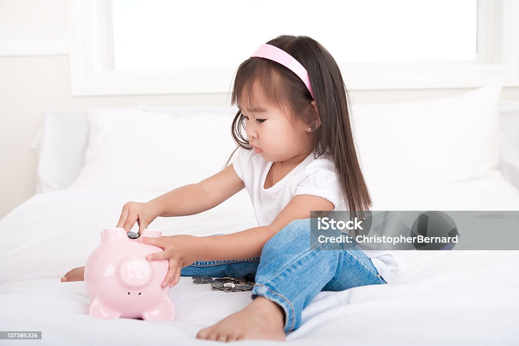 Garota colocando dinheiro na piggy bank - Foto de stock de 2-3 Anos royalty-free