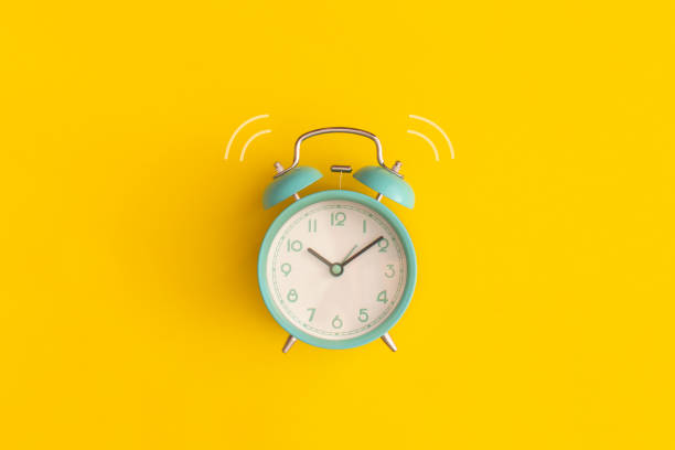 istock Blue alarm clock on yellow background. Top view with copy space. Flat lay. Back to school concept. 1373857716