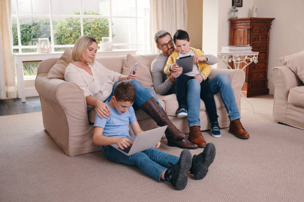 istock Shot of a young family bonding while using their electronic devices together at home 1373861903