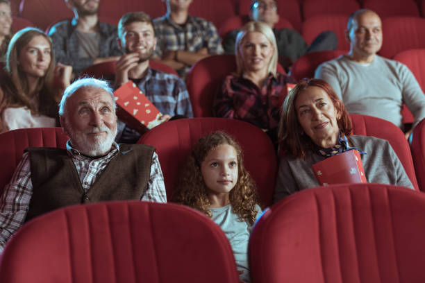Little girl and grandparents in cinema stock photo