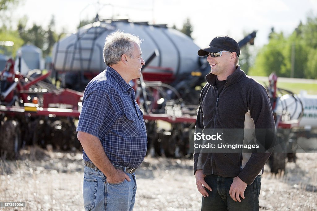 Farming Two men with tractors on the farm. It is seeding time in the spring. Farmer Stock Photo