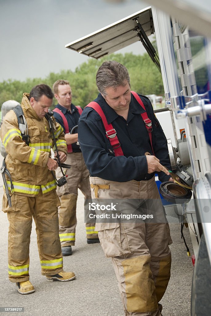 Firefighters Firefighters working on their truck. Accidents and Disasters Stock Photo