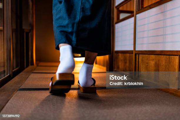 Japanese Ryokan Machiya Traditional House With Man In Kimono Back Behind Closeup Of Legs Feet With Tabi White Socks And Geta Shoes Walking By Shoji Sliding Paper Door Stock Photo - Download Image Now