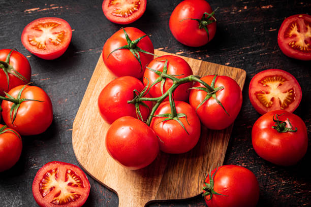 istock Fresh tomatoes on a wooden cutting board. 1373904145