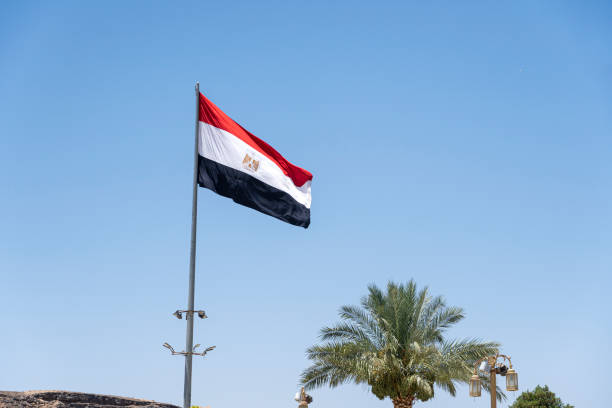 Flag on pole against blue sky. Large flag of Egypt waving in wind Flag on pole against blue sky. Large flag of Egypt waving in the wind egyptian flag stock pictures, royalty-free photos & images