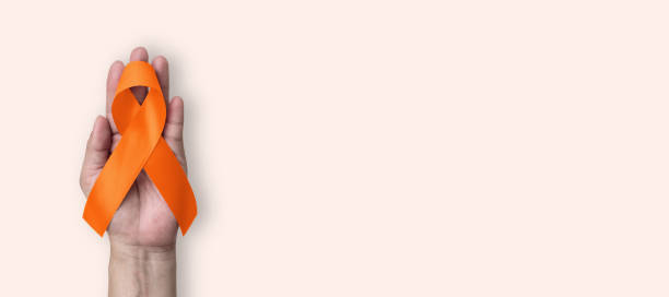 cinta naranja para el mes de concientización sobre el cáncer de riñón, leucemia, esclerosis múltiple, lupus, enfermedad de tdah, autolesión y maltrato animal con arco en la mano - beast cancer awareness month fotografías e imágenes de stock