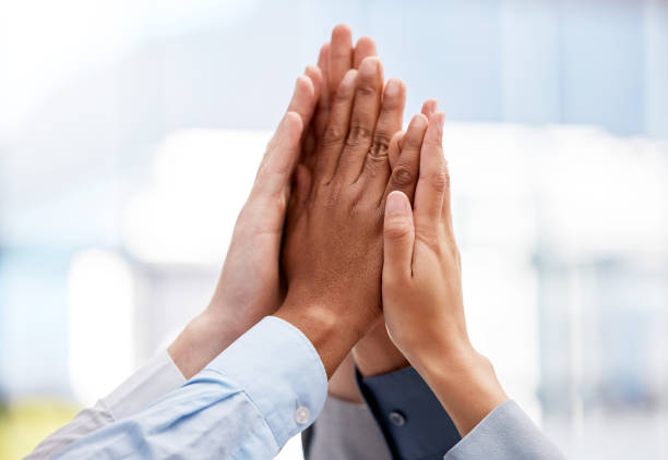 shot of a team of business people high fiving one another - excitement business person ecstatic passion imagens e fotografias de stock