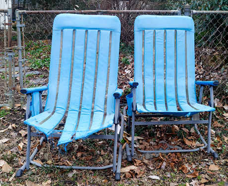 Discarded powder blue deck chairs.