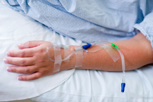 Stock photo of a patient's arm in the hospital with an IV.