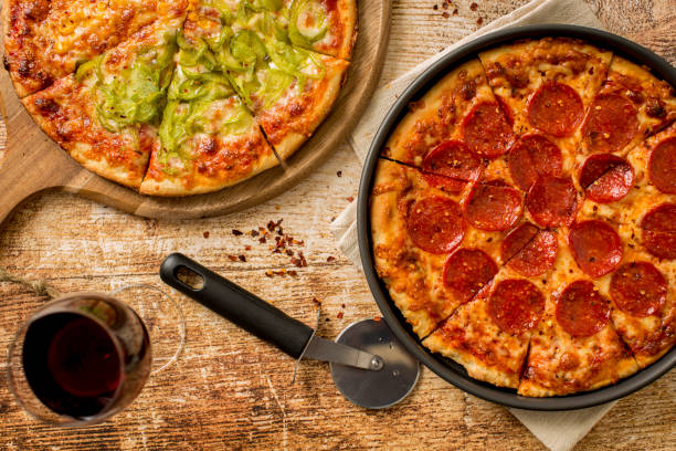 istock Green pepper pizza and Pepperoni pizza on wood table 1373960563