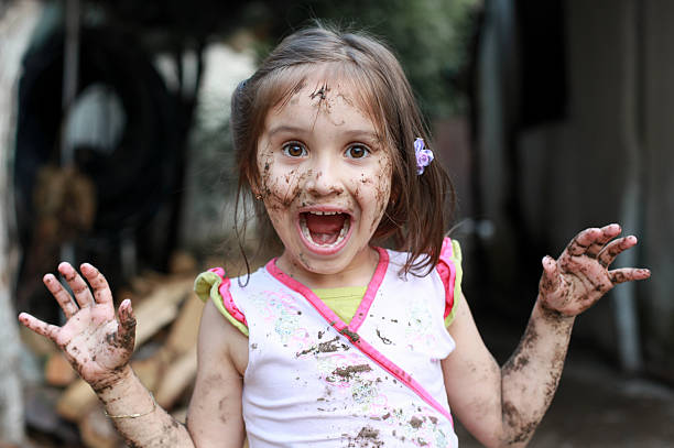 istock A young girl covered in mud with her mouth open 137396977