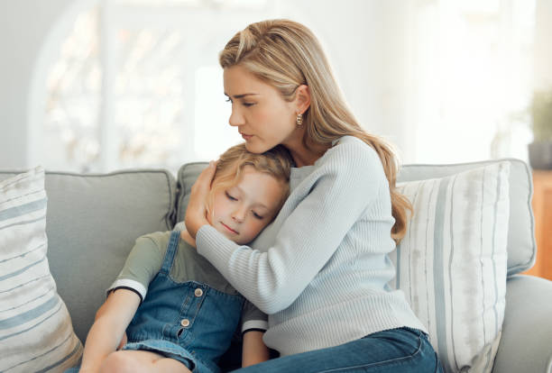 Shot of a young mother comforting her daughter on the sofa at home Bullies are everywhere, be their safe place family mother poverty sadness stock pictures, royalty-free photos & images