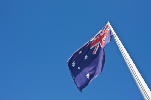 The Australian flag flying in the wind with the distinctive stars of the Southern Cross.