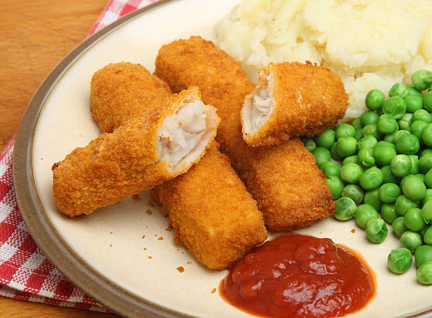 Fish Fingers Meal Fish fingers with mashed potato, peas and tomato sauce. fish stick stock pictures, royalty-free photos & images