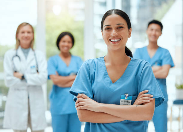 снимок группы практикующих врачей, стоящих вместе в больнице - scrubs стоковые фото и изображения