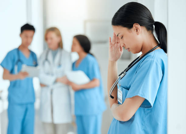 scatto di un medico che sembra stressato nel bel mezzo di una riunione in ospedale - emotional stress looking group of people clothing foto e immagini stock