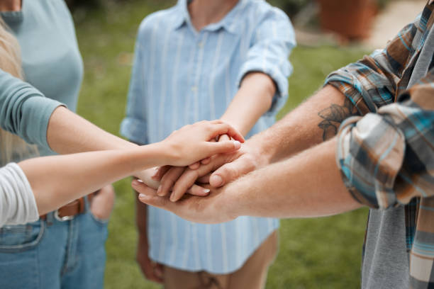 istock Shot of an unrecognizable group of people stacking their hams while standing outside 1374045882