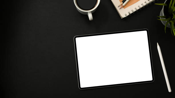 istock Top view of Modern dark office desk with portable tablet 1374116495